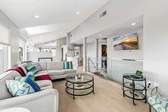 Living area with large sectional couch, smart TV, ocean views, and a gas fireplace!