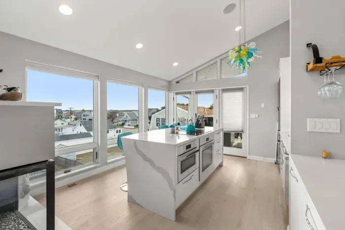 Completely renovated and fully equipped kitchen with high end Miele appliances, including an induction stove top and dishwasher. The picture windows in the space are sure to amaze!