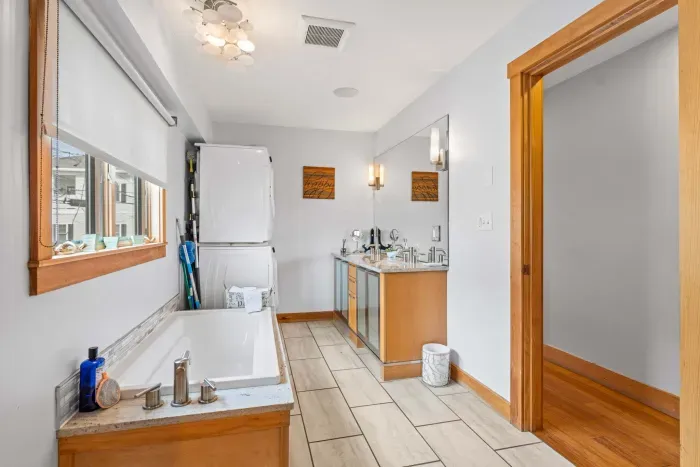 The second bathroom in the Yoga unit with a stacked washer and dryer, soaking tub and tiled shower! Clean towels provided for all guests. 