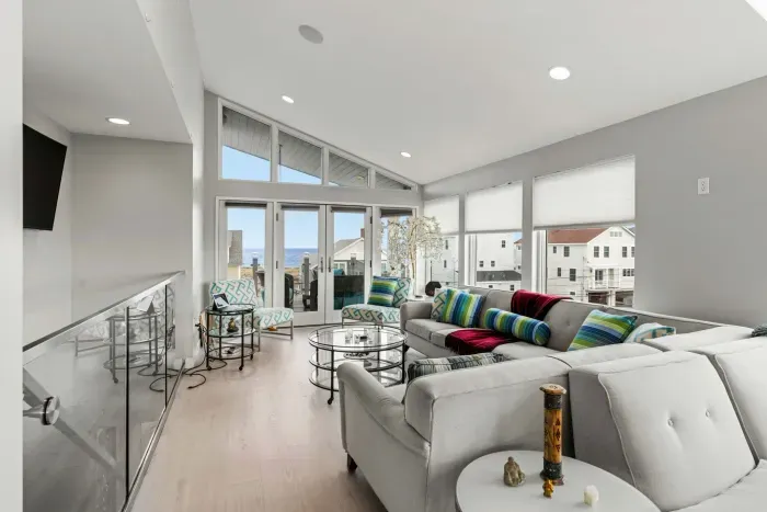 Living area with large sectional couch, smart TV, ocean views, and a gas fireplace!