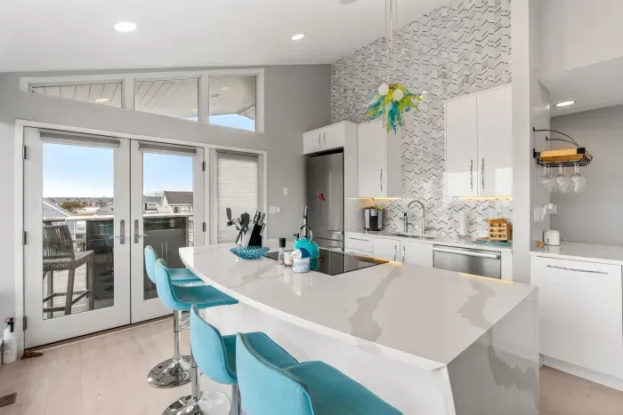 Completely renovated and fully equipped kitchen with high end Miele appliances, including an induction stove top and dishwasher. Venetian glass light fixtures and counter to ceiling tiled accent wall