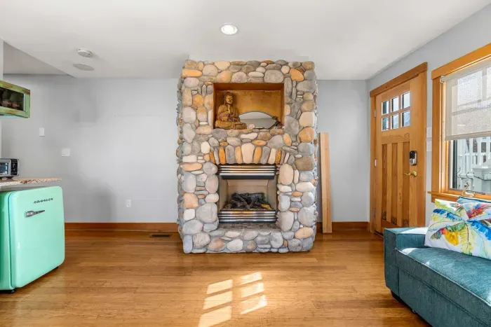 Yoga unit living area with additional exit, gas fireplace, and small kitchenette with a sink, coffee maker and mini fridge