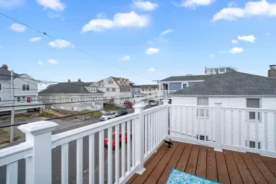 Primary bedroom with king bed, flat smart TV, work-from-home desk and balcony facing the ocean.