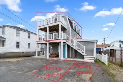 Exterior of property. This unit is located on the 2nd and 3rd floors, and comes with 2 off-street parking spots (parked side-by-side on the ride-hand side of the driveway)