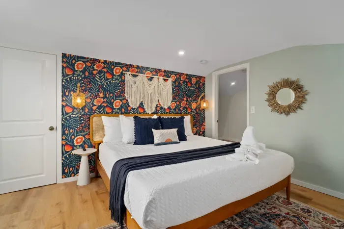 Primary bedroom with king bed, flat smart TV, work-from-home desk and balcony facing the ocean.