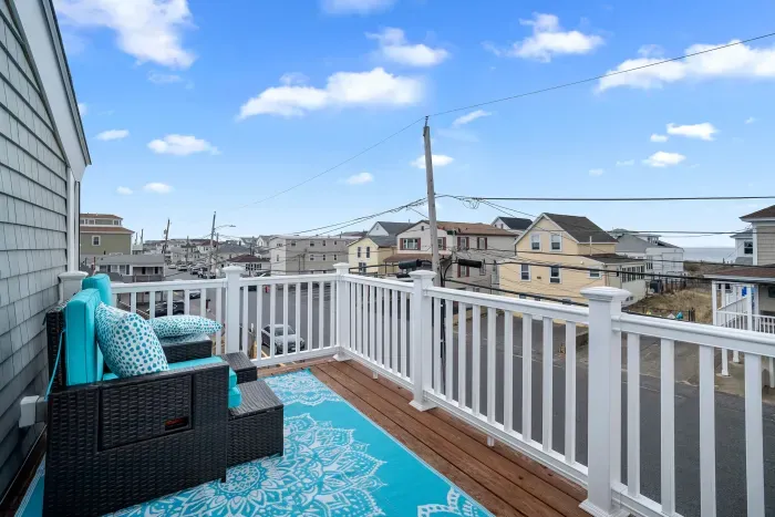 Primary bedroom with king bed, flat smart TV, work-from-home desk and balcony facing the ocean.