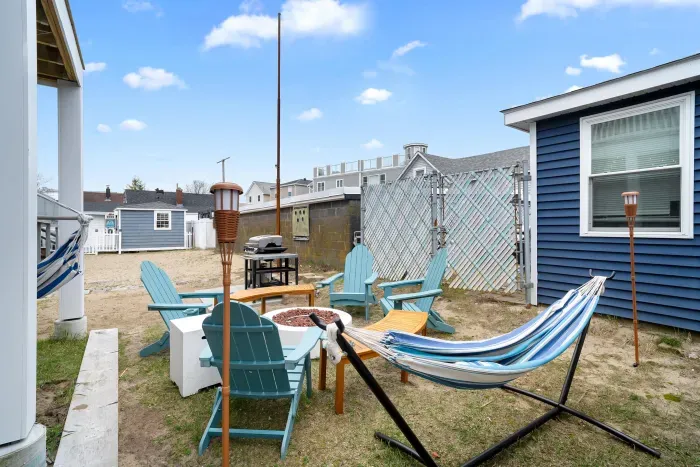 Common back yard area, with common amenities shared with the unit upstairs -- string lights, gas firepit, sitting area, hammock, swinging chairs - WE NO LONGER HAVE A GRILL