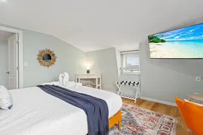 Primary bedroom with king bed, flat smart TV, work-from-home desk and balcony facing the ocean.