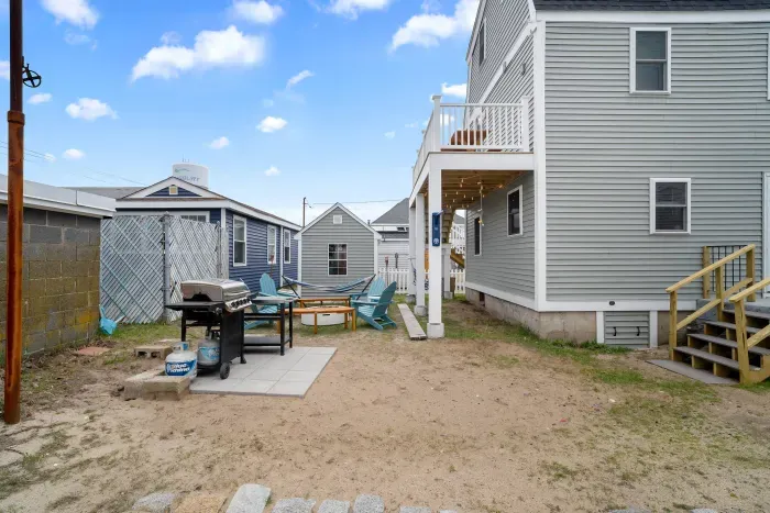 Common back yard area, with common amenities shared with the unit upstairs -- string lights, gas firepit, sitting area, hammock, swinging chairs - WE NO LONGER HAVE A GRILL