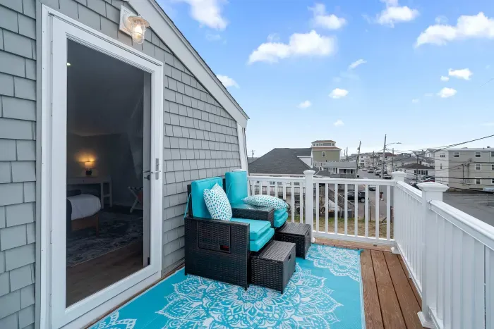 Primary bedroom with king bed, flat smart TV, work-from-home desk and balcony facing the ocean.