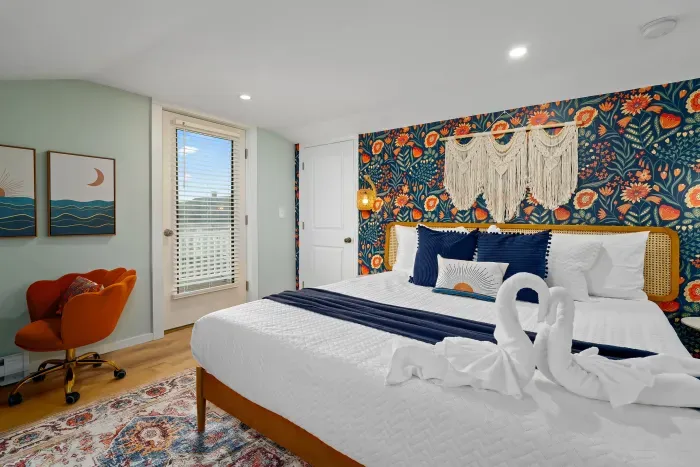 Primary bedroom with king bed, flat smart TV, work-from-home desk and balcony facing the ocean.