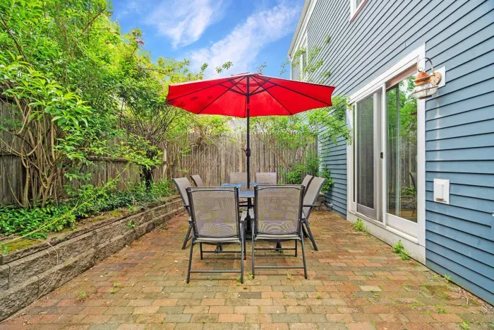 Private back patio with 8-person dining table and gas grill