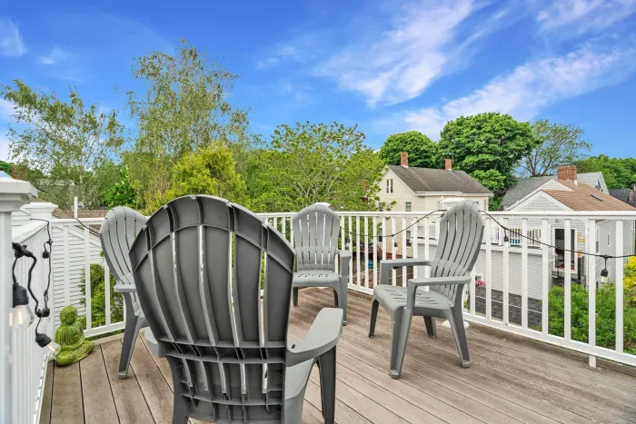 Private rooftop deck with seating, string lights, and partial views of the Merrimack River