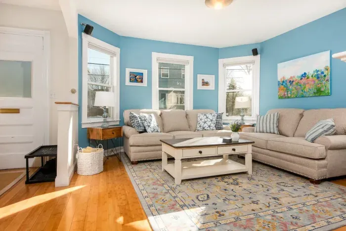 Large, sunny and comfortable living room with mounted TV and electric fireplace for all guests to enjoy.