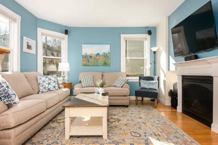 Large, sunny and comfortable living room with mounted TV and electric fireplace for all guests to enjoy.