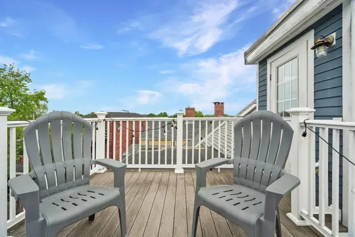 Private rooftop deck with seating, string lights, and partial views of the Merrimack River