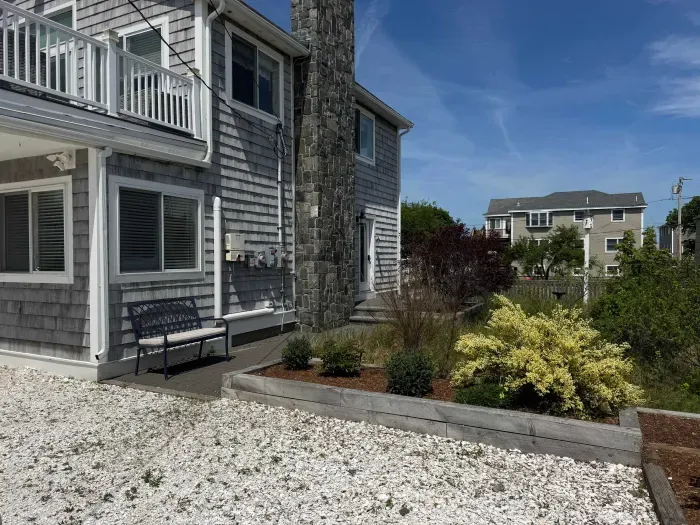 The main entrance is located right by the chimney. This home has an awesome seagrass yard!