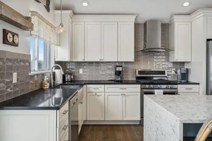 Fully equipped and renovated kitchen with waterfall island, gas range, dishwasher, and more. 