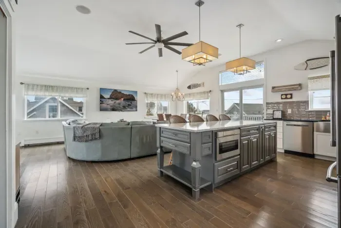 The upstairs living area with a comfy couch and large smart TV. Fully equipped and renovated kitchen along access to the upper deck is located here. 