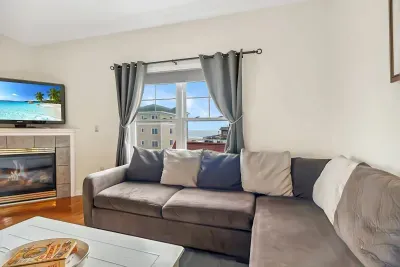 Living room with ocean views featuring both a sectional and pull-out couch, and access to the private balcony!