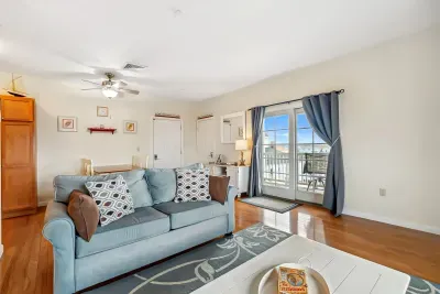 Living room with ocean views featuring both a sectional and pull-out couch, and access to the private balcony!