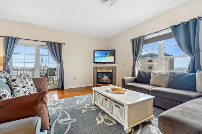 Living room with ocean views featuring both a sectional and pull-out couch, and access to the private balcony!