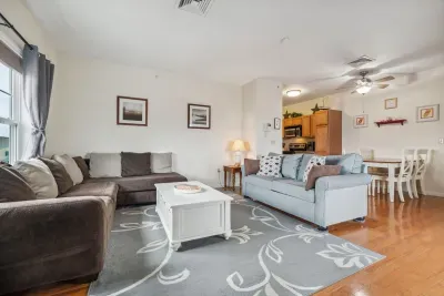 Living room with ocean views featuring both a sectional and pull-out couch, and access to the private balcony!