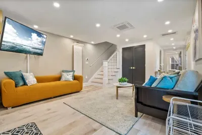 Enter into the living area where there is a large smart TV, a couch, and a futon.