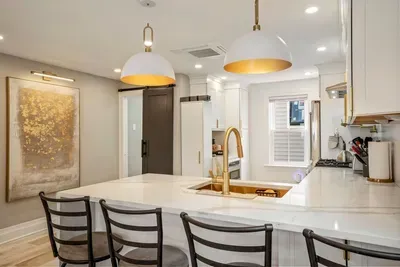 High end kitchen featuring sleek quartz countertops. Seating for four at the bar.