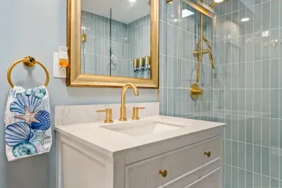 Bathroom #1 features a large standing tile shower, shampoo, body wash, conditioner, and clean towels.