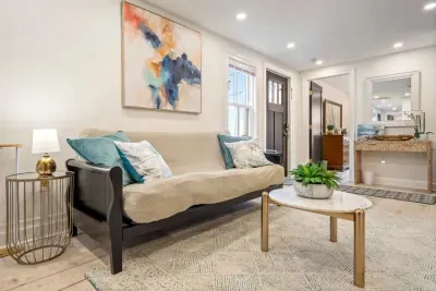 Enter into the living area where there is a large smart TV, a couch, and a futon.