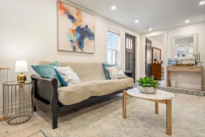 Enter into the living area where there is a large smart TV, a couch, and a futon.