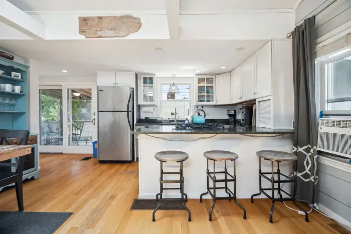 Fully equipped kitchen with all necessary appliances, 3-seater eat-in counter, and 6-person dining table