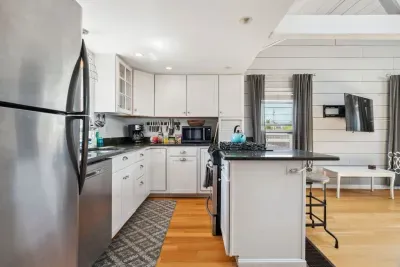 Fully equipped kitchen with all necessary appliances, 3-seater eat-in counter, and 6-person dining table
