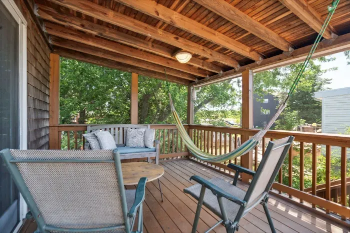 Screened-in deck area with outdoor seating and hammock