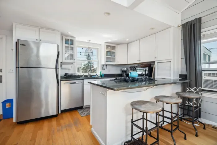 Fully equipped kitchen with all necessary appliances, 3-seater eat-in counter, and 6-person dining table