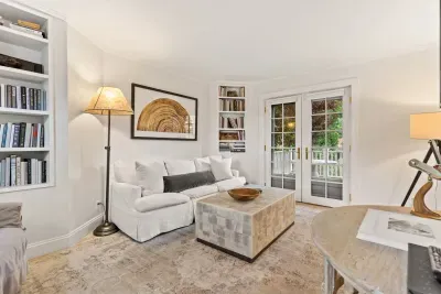 Living room with smart TV, couch, accent chairs and entrance to private deck/garden.