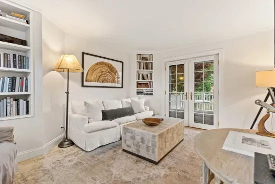 Living room with smart TV, couch, accent chairs and entrance to private deck/garden.