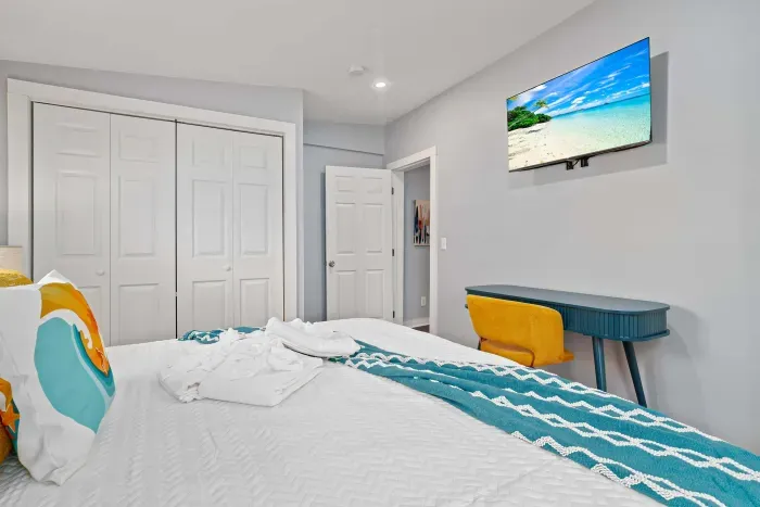 Primary bedroom #1 on the 1st floor, with king bed, mounted smart TV, closet and work-from-home desk
