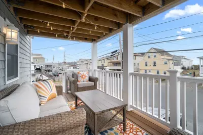 Private covered front deck, on the second level, facing ocean, with string lights