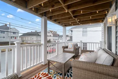 Private covered front deck, on the second level, facing ocean, with string lights