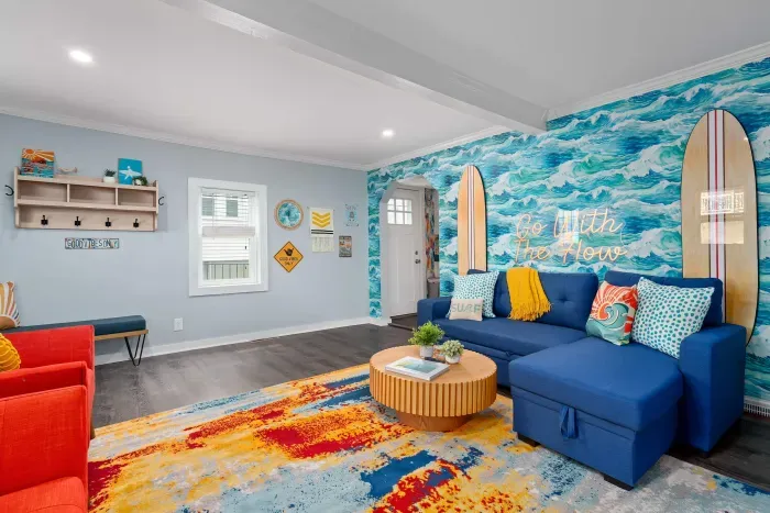 First Living Room (one of 2 living rooms at the property), with "go with the flow" neon light sign, flat screen smart TV and sleeper sofa
