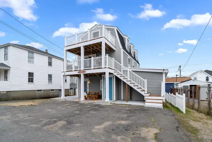 Exterior of property. This Property comes with 4 off-street parking spots (parked side-by-side in the driveway), has several private decks (front and back), along with fun and relaxing ground-level outdoor spaces.