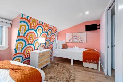 Bedroom #4 (3rd floor) with two twin beds, mounted smart TV and ensuite bathroom with walk-in tiled shower.