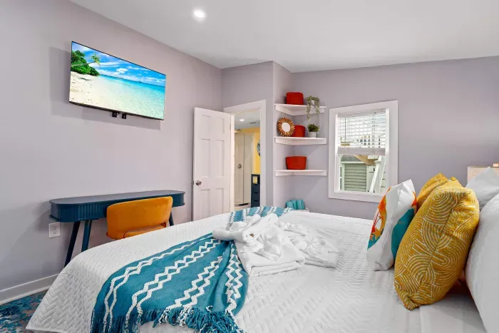 Primary bedroom #1 on the 1st floor, with king bed, mounted smart TV, closet and work-from-home desk
