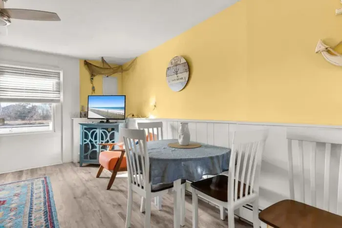 Newly renovated, open kitchen & living room with all new appliances, breakfast bar, 4-seat dining table, couch, accent chair and flat screen smart Roku TV.