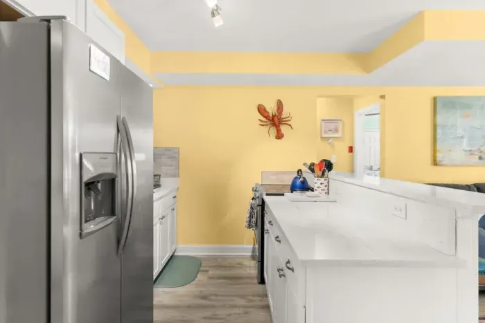 Newly renovated, open kitchen & living room with all new appliances, breakfast bar, 4-seat dining table, couch, accent chair and flat screen smart Roku TV.