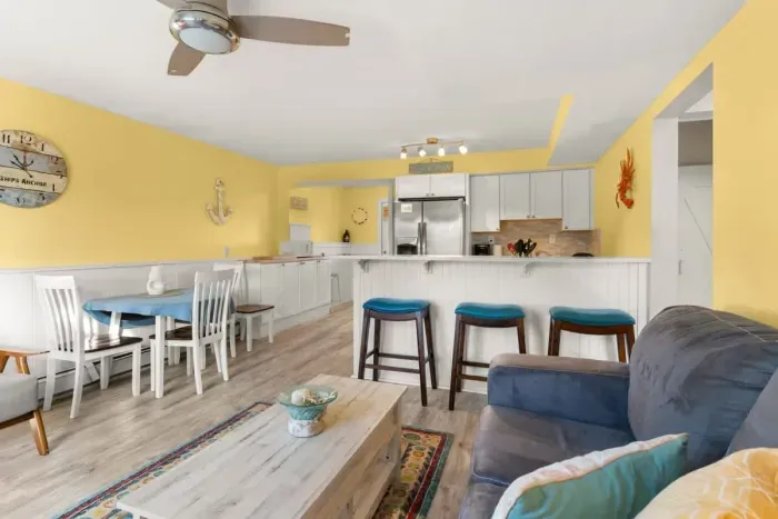 Newly renovated, open kitchen & living room with all new appliances, breakfast bar, 4-seat dining table, couch, accent chair and flat screen smart Roku TV.