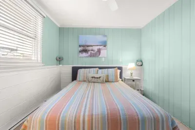 Primary bedroom, queen-sized bed, attached 1/2 bathroom and smart Roku TV