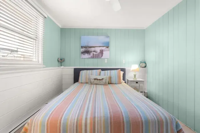 Primary bedroom, queen-sized bed, attached 1/2 bathroom and smart Roku TV